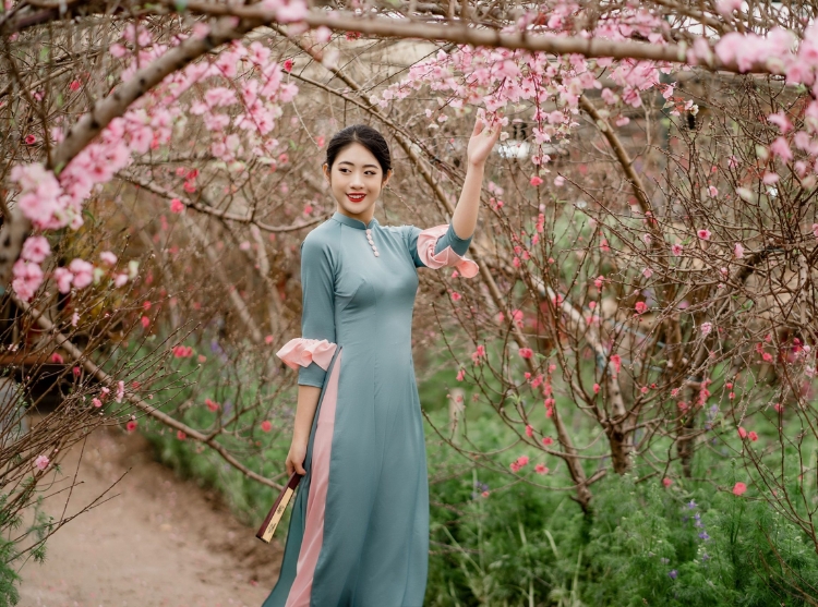 Tạo dáng chụp ảnh áo dài Tết với vườn hoa đào